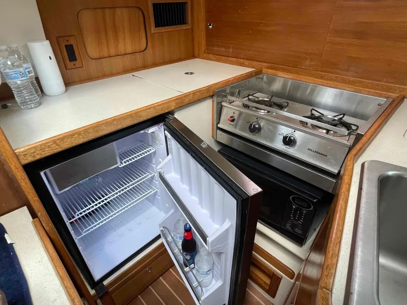Slide: The Image of Compact kitchen in a 2006 Hunter 309 boat with fridge and stove. - 25
