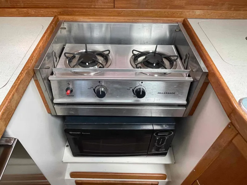 Slide: The Image of Two-burner stove and microwave in a 2006 Hunter 309 boat kitchen. - 27