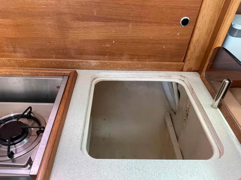 Slide: The Image of Compact kitchen area in a 2006 Hunter 309 boat, featuring a stove and storage space. - 29