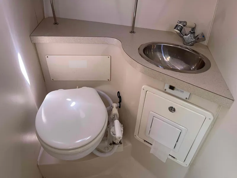 Slide: The Image of Compact bathroom in a 2006 Hunter 309 boat with toilet and stainless steel sink. - 39