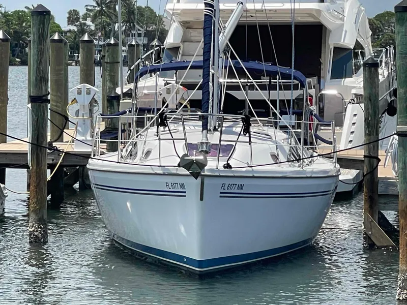 Slide: The Image of Hunter 309 sailboat, 2006 model, docked at marina with clear water and wooden posts. - 40