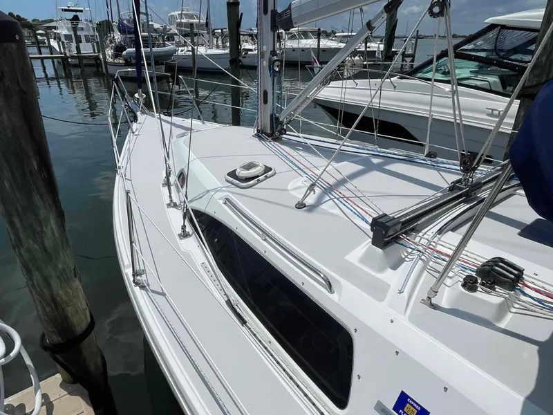 Slide: The Image of 2006 Hunter 309 sailboat docked at marina, showcasing deck and rigging. - 45