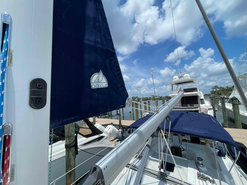Slide: The Image of Sailboat Hunter 309, 2006 model, docked with blue sails under a partly cloudy sky. - 49