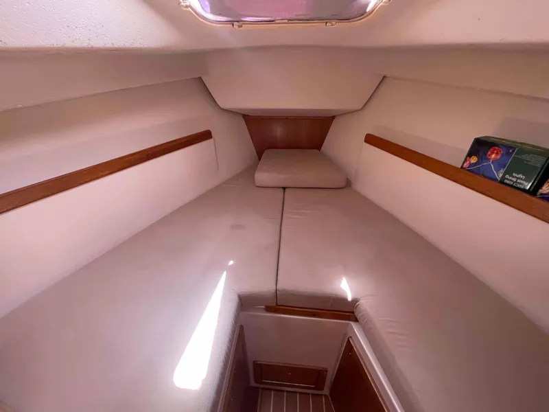 Slide: The Image of Interior cabin of a 2006 Hunter 309 sailboat with cushioned seating and wooden accents. - 6