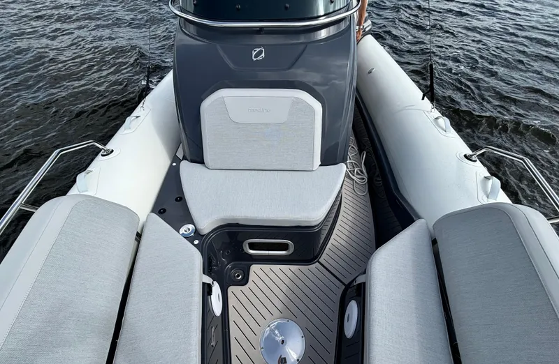 Slide: The Image of 2024 Zodiac Medline 9 boat interior with cushioned seating and sleek design on water. - 3