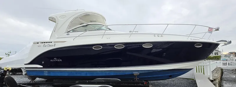 The Image of 2008 Rinker 400 Express Cruiser boat with sleek design, docked on a trailer. - 0