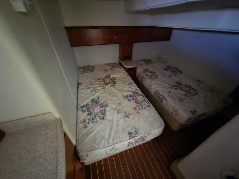 Slide: The Image of 2008 Rinker 400 Express Cruiser cabin with twin beds and floral bedding. - 10