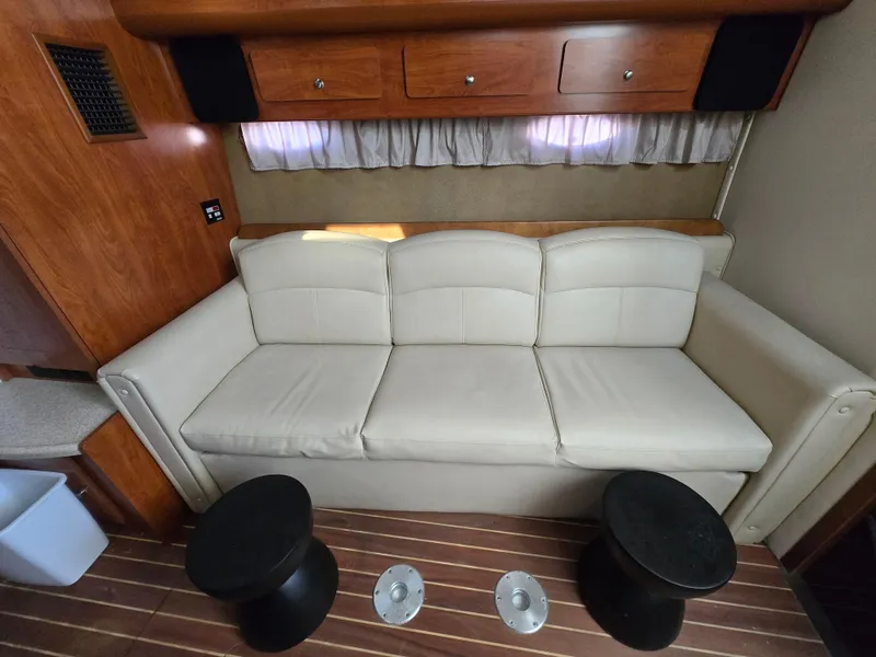 Slide: The Image of 2008 Rinker 400 Express Cruiser interior with beige sofa and wooden cabinetry. - 12