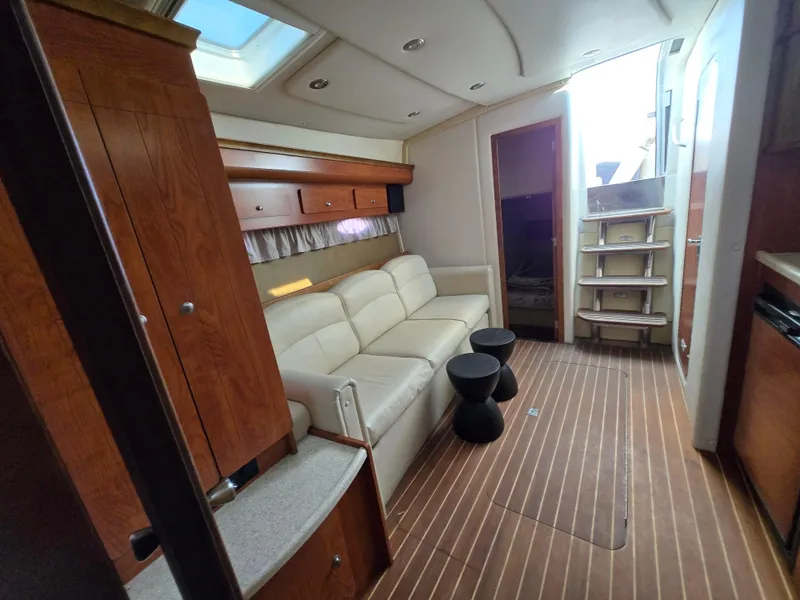 Slide: The Image of 2008 Rinker 400 Express Cruiser interior with sofa, wooden cabinets, and stairs. - 19
