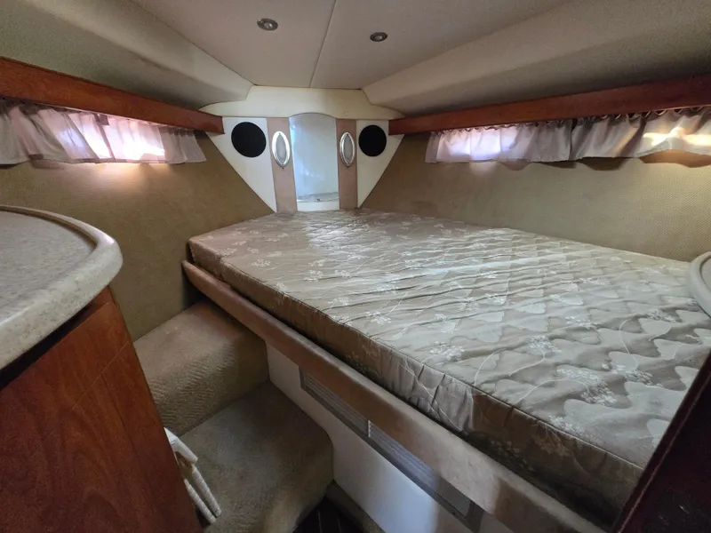 Slide: The Image of 2008 Rinker 400 Express Cruiser cabin with bed, wood accents, and soft lighting. - 20