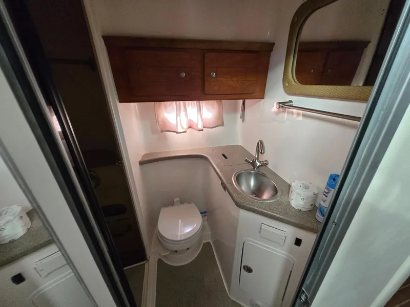 Slide: The Image of 2008 Rinker 400 Express Cruiser bathroom with sink, toilet, and storage cabinets. - 21