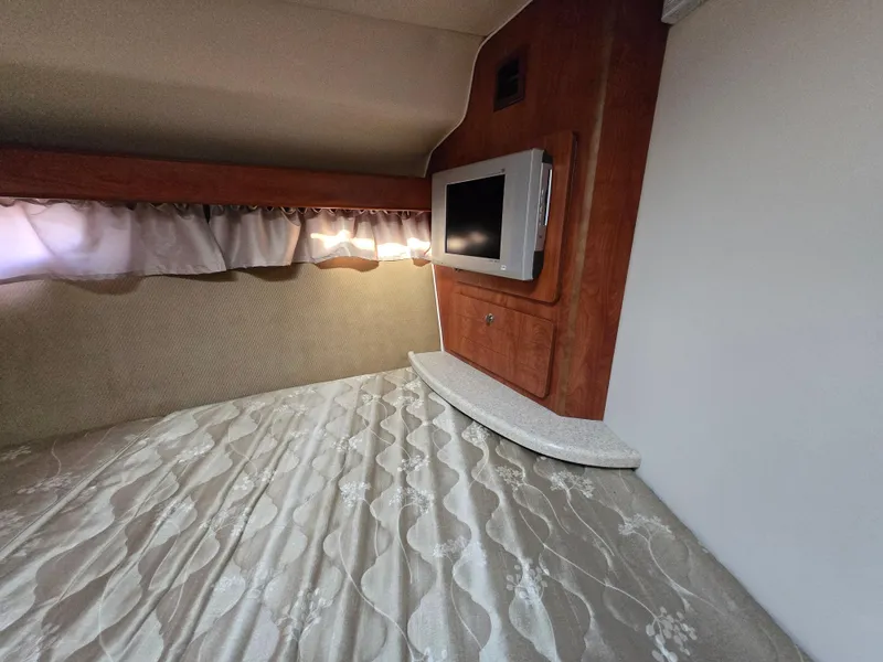 Slide: The Image of 2008 Rinker 400 Express Cruiser cabin interior with TV and bed. - 23