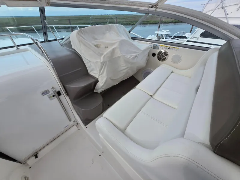 Slide: The Image of 2008 Rinker 400 Express Cruiser interior with white seating and covered helm. - 37