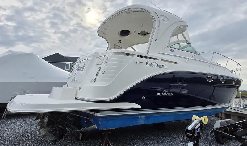 Slide: The Image of 2008 Rinker 400 Express Cruiser boat on a trailer, parked outdoors under cloudy skies. - 4