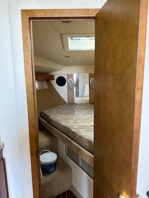 Slide: The Image of 2008 Rinker 400 Express Cruiser cabin interior with bed and wooden door. - 45