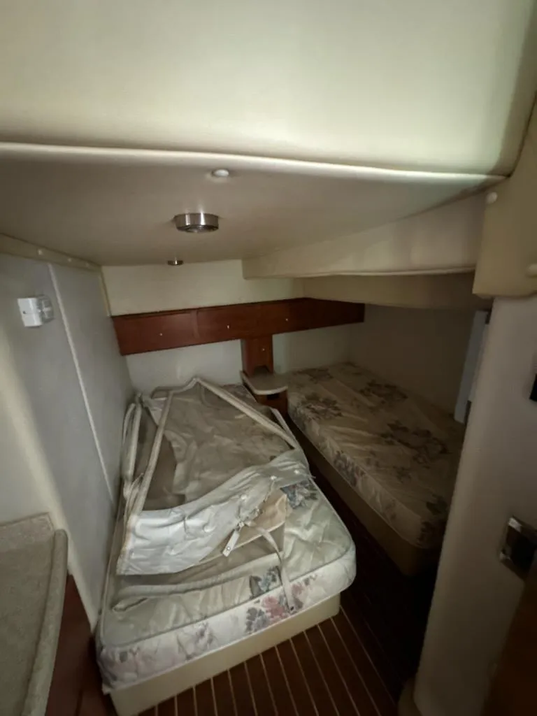 Slide: The Image of 2008 Rinker 400 Express Cruiser cabin with twin beds and wooden flooring. - 46