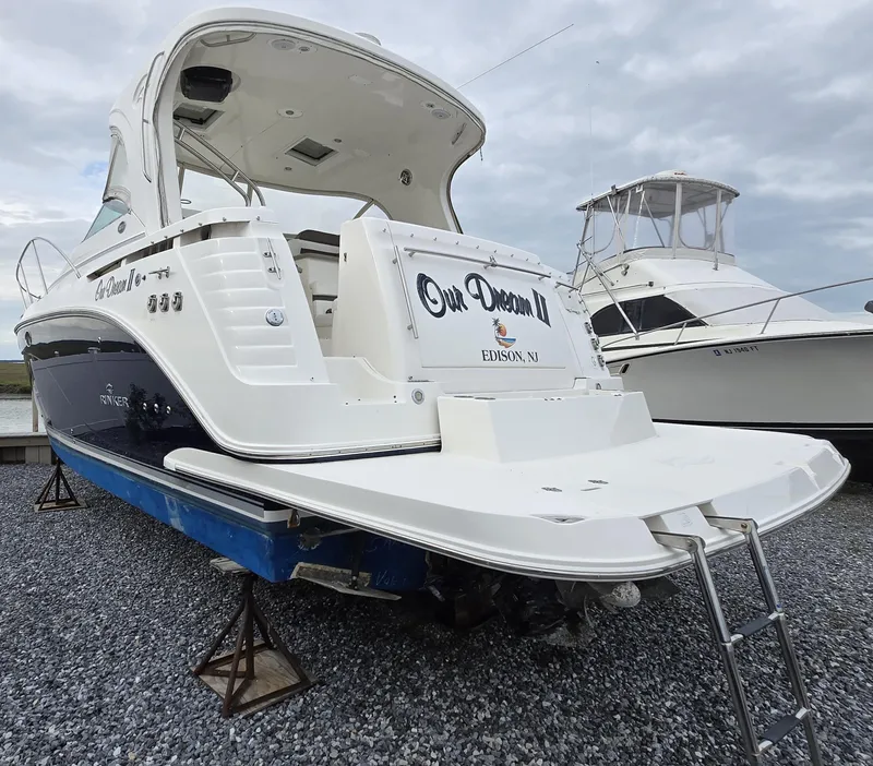 Slide: The Image of 2008 Rinker 400 Express Cruiser on gravel, rear view with ladder and nameplate. - 8