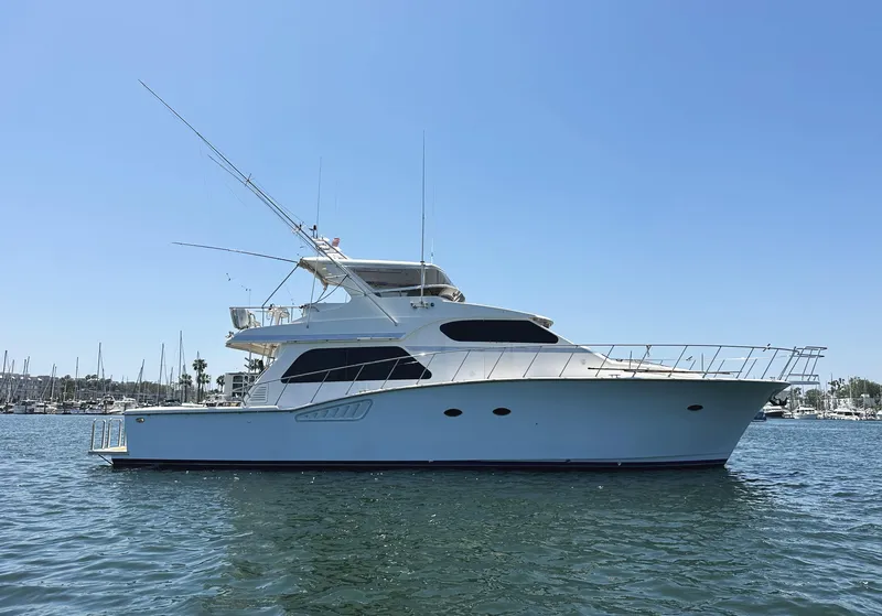 Slide: The Image of 2000 Mikelson 61 Sportfisher yacht on calm water under clear blue sky. - 0