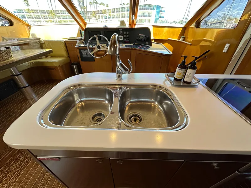 Slide: The Image of Luxury kitchen sink on 2000 Mikelson 61 Sportfisher yacht, featuring dual basins and modern fixtures. - 23