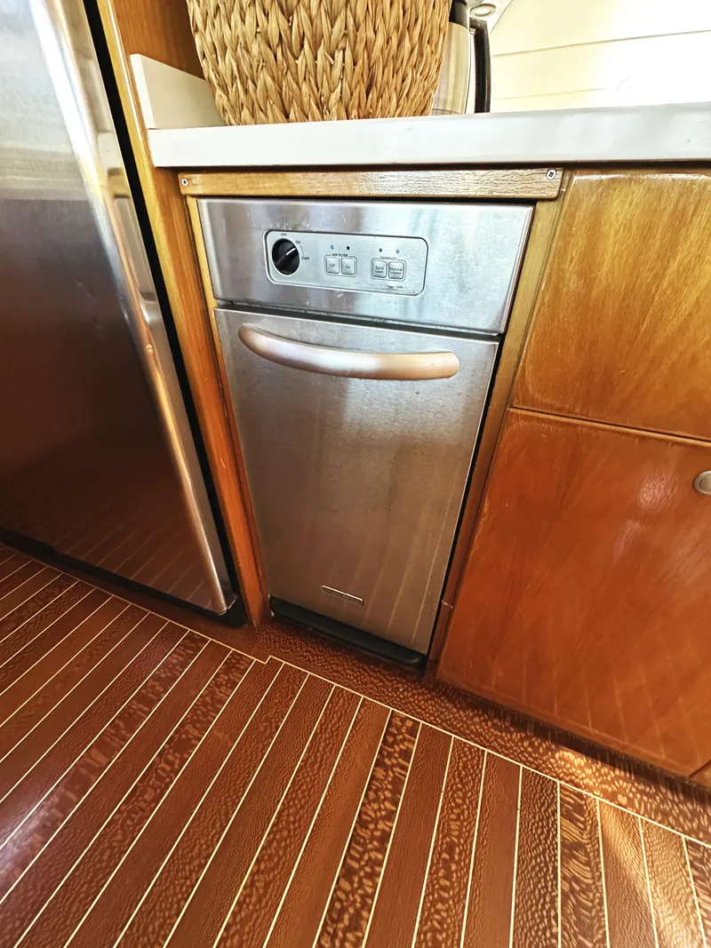 Slide: The Image of Compact kitchen area in a 2000 Mikelson 61 Sportfisher yacht with stainless steel dishwasher. - 26