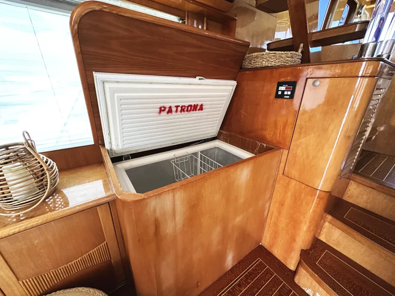 Slide: The Image of Open freezer on 2000 Mikelson 61 Sportfisher yacht, wooden interior, labeled "Patrona". - 28