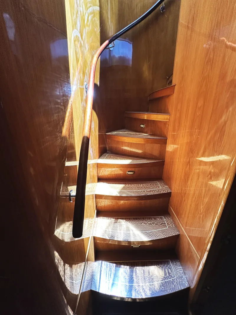 Slide: The Image of Wooden staircase inside 2000 Mikelson 61 Sportfisher yacht, featuring polished handrails. - 36