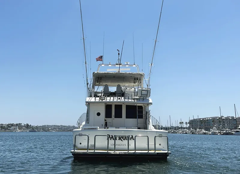 Slide: The Image of Mikelson 61 Sportfisher 2000 yacht on water, rear view, clear sky, marina background. - 4