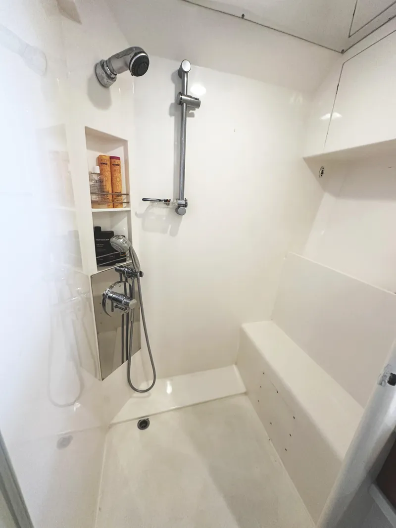 Slide: The Image of Shower area in a 2000 Mikelson 61 Sportfisher yacht, featuring modern fixtures and built-in seating. - 44
