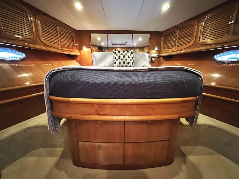 Slide: The Image of Luxurious cabin interior of 2000 Mikelson 61 Sportfisher with wooden cabinetry and cozy bedding. - 48