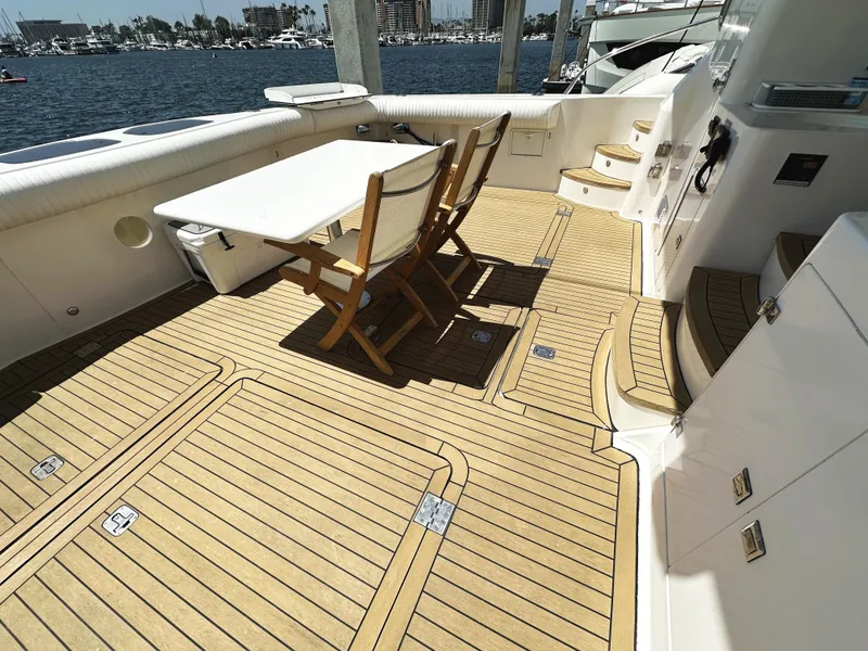 Slide: The Image of Deck of 2000 Mikelson 61 Sportfisher yacht with table and chairs, overlooking marina. - 5