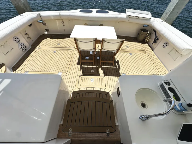 Slide: The Image of Spacious deck of 2000 Mikelson 61 Sportfisher with seating and table, overlooking water. - 7