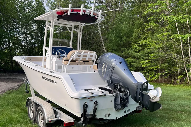 Slide: The Image of 2019 Sportsman Heritage 211 Center Console boat on trailer, parked on grass. - 10