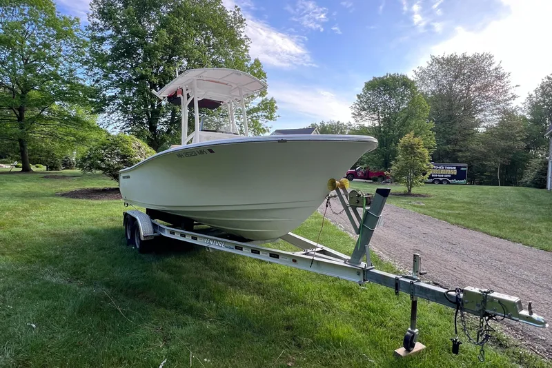 Slide: The Image of 2019 Sportsman Heritage 211 Center Console boat on trailer in grassy area. - 11