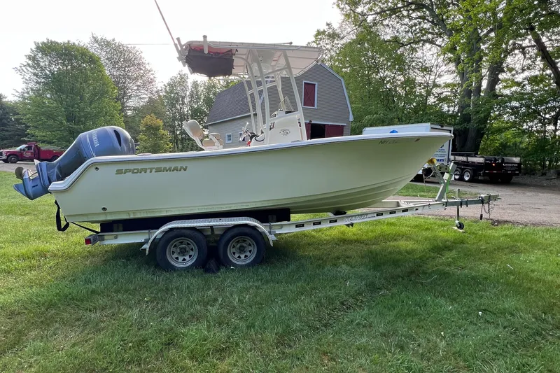 Slide: The Image of 2019 Sportsman Heritage 211 Center Console boat on trailer, parked on grass. - 9