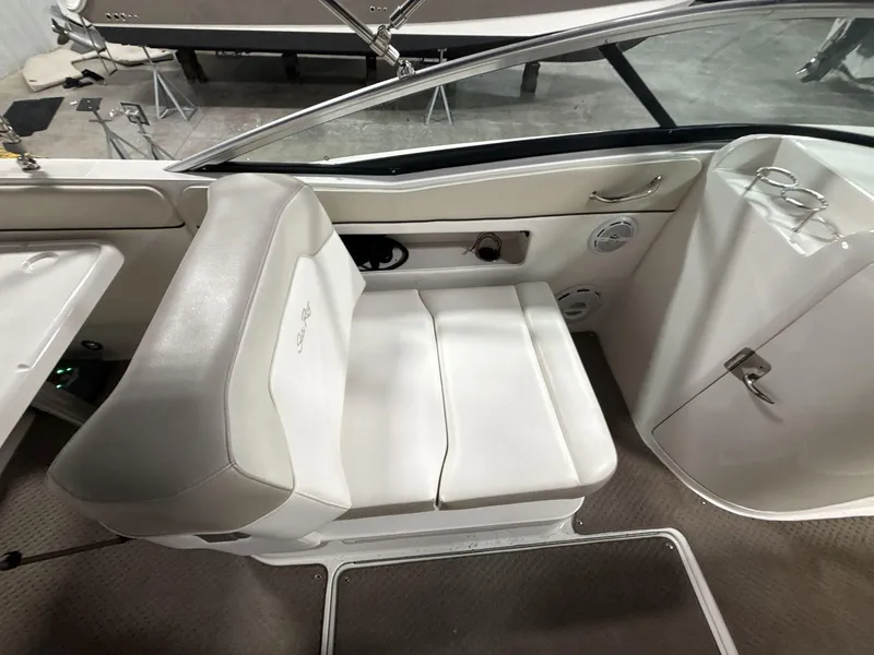 Slide: The Image of 2013 Sea Ray 300 Sundeck interior seating with white upholstery and cup holders. - 10