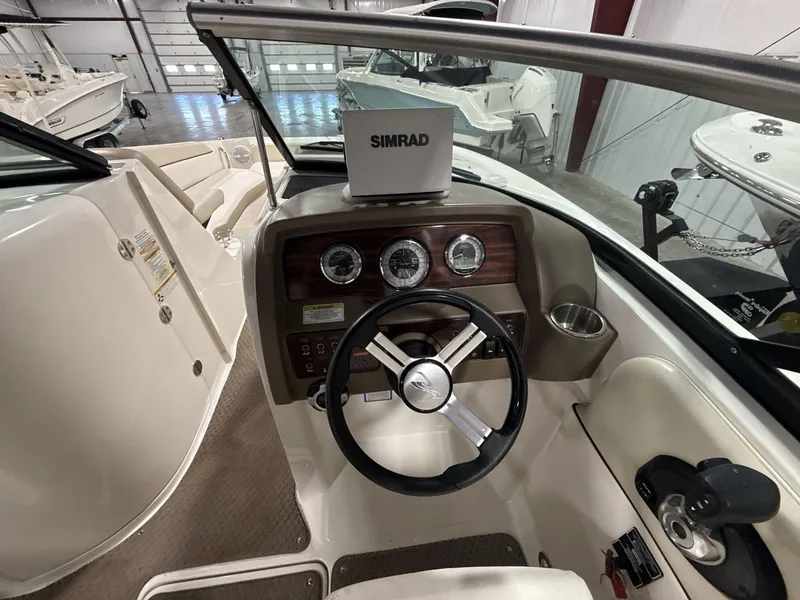 Slide: The Image of 2013 Sea Ray 300 Sundeck cockpit with steering wheel and Simrad display. - 11
