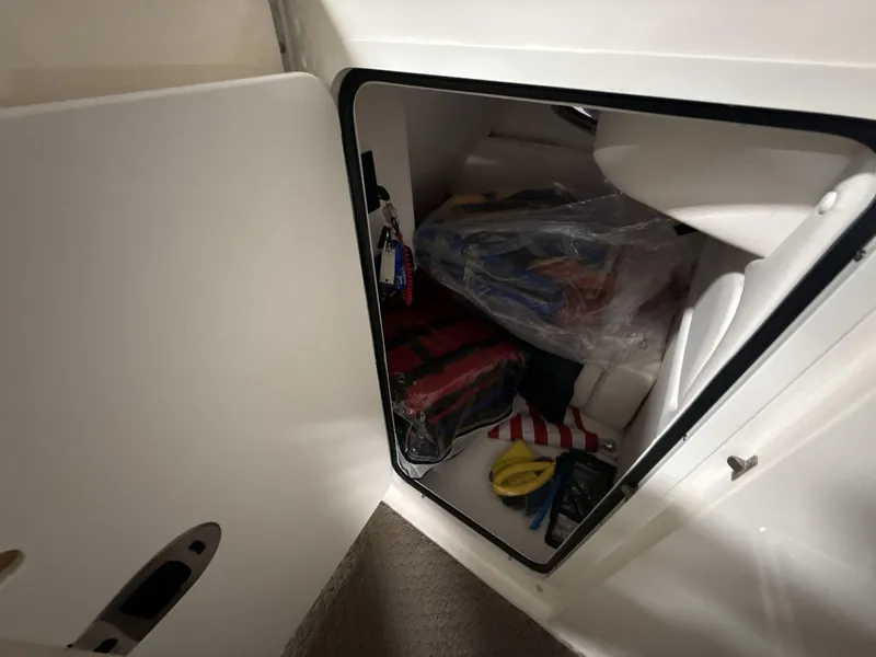 Slide: The Image of Storage compartment on a 2013 Sea Ray 300 Sundeck, containing boating accessories. - 14
