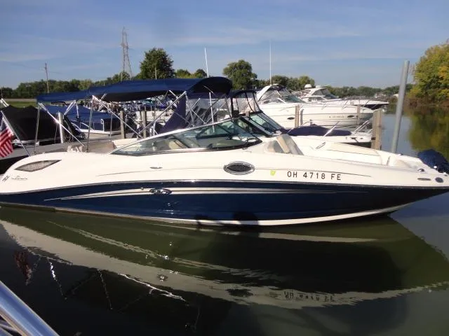 Slide: The Image of 2013 Sea Ray 300 Sundeck boat docked in a marina, featuring sleek design and blue accents. - 17