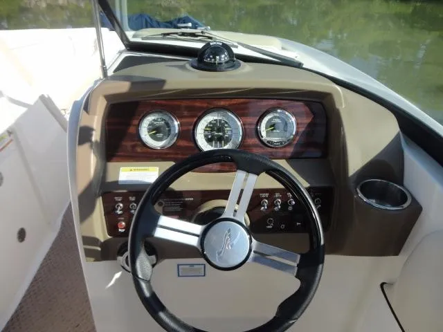 Slide: The Image of 2013 Sea Ray 300 Sundeck dashboard with steering wheel and instrument panel. - 27