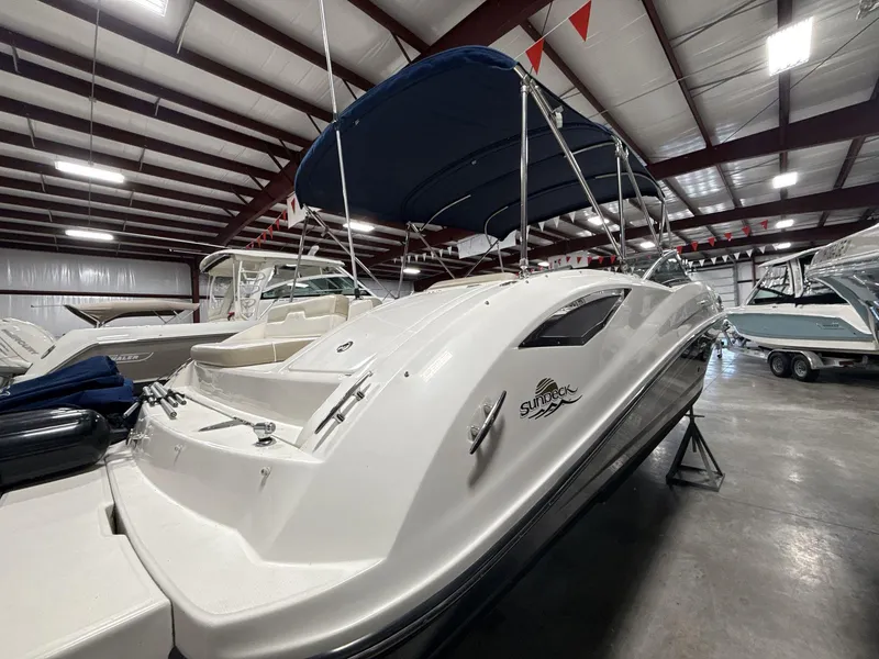Slide: The Image of 2013 Sea Ray 300 Sundeck boat in indoor storage, featuring a sleek white design. - 5