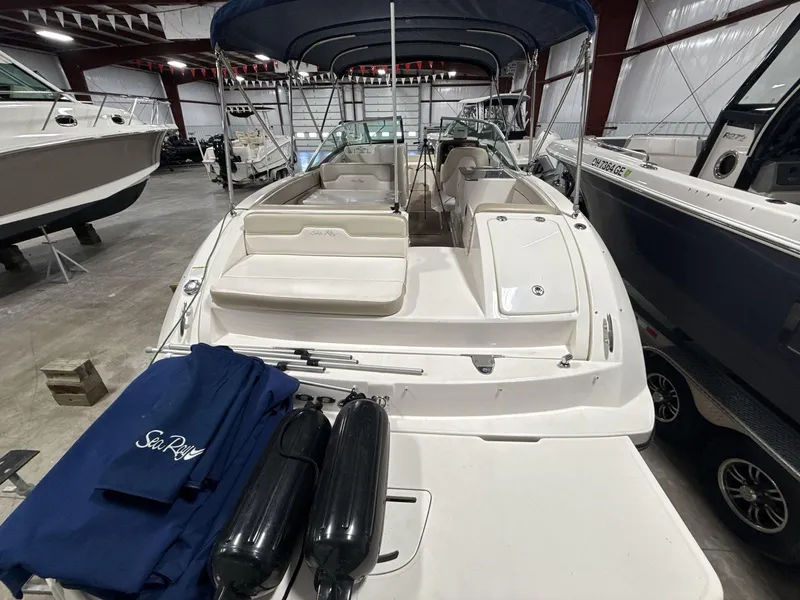 Slide: The Image of 2013 Sea Ray 300 Sundeck boat in storage, featuring spacious seating and protective covers. - 6