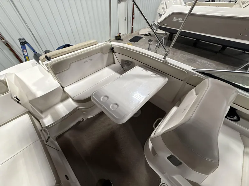 Slide: The Image of 2013 Sea Ray 300 Sundeck interior with seating and table in a showroom. - 7