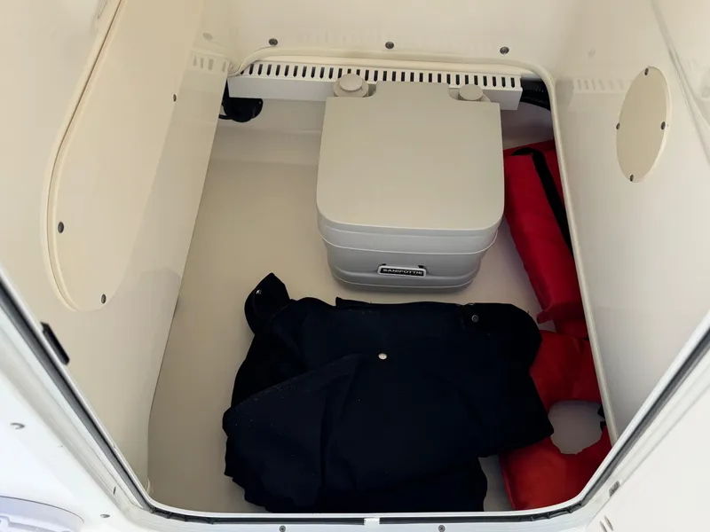 Slide: The Image of Storage compartment in a 2007 Boston Whaler 200 Dauntless with life jackets and portable toilet. - 11