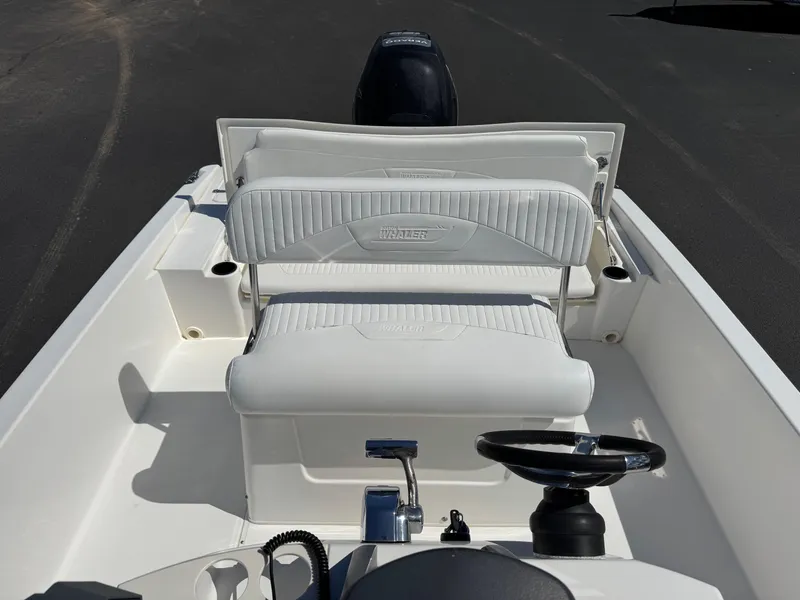 Slide: The Image of 2007 Boston Whaler 200 Dauntless boat interior with white seating and steering wheel. - 13