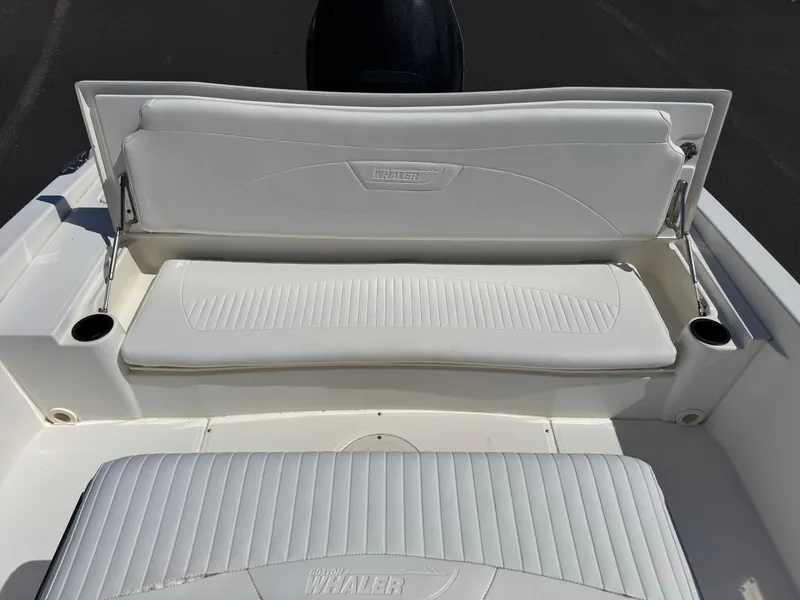 Slide: The Image of 2007 Boston Whaler 200 Dauntless boat seating with white cushioned upholstery and cup holders. - 14