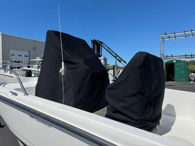 Slide: The Image of 2007 Boston Whaler 200 Dauntless boat with covered seats, docked outdoors. - 16