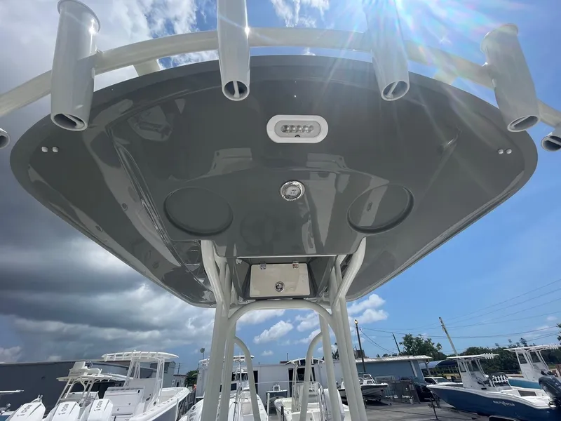 Slide: The Image of 2025 Pathfinder 2200 TRS boat with T-top and rod holders under a sunny sky. - 14