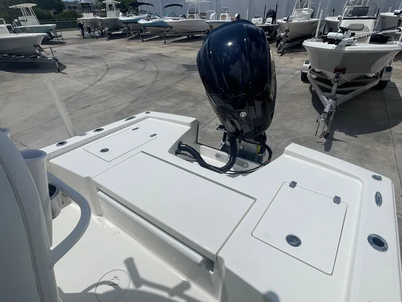 Slide: The Image of 2025 Pathfinder 2200 TRS boat with outboard motor, docked among other boats. - 6