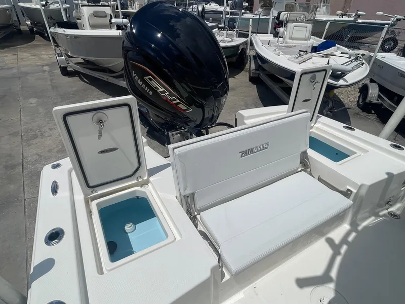 Slide: The Image of 2025 Pathfinder 2200 TRS boat with outboard motor and seating, docked in a marina. - 7