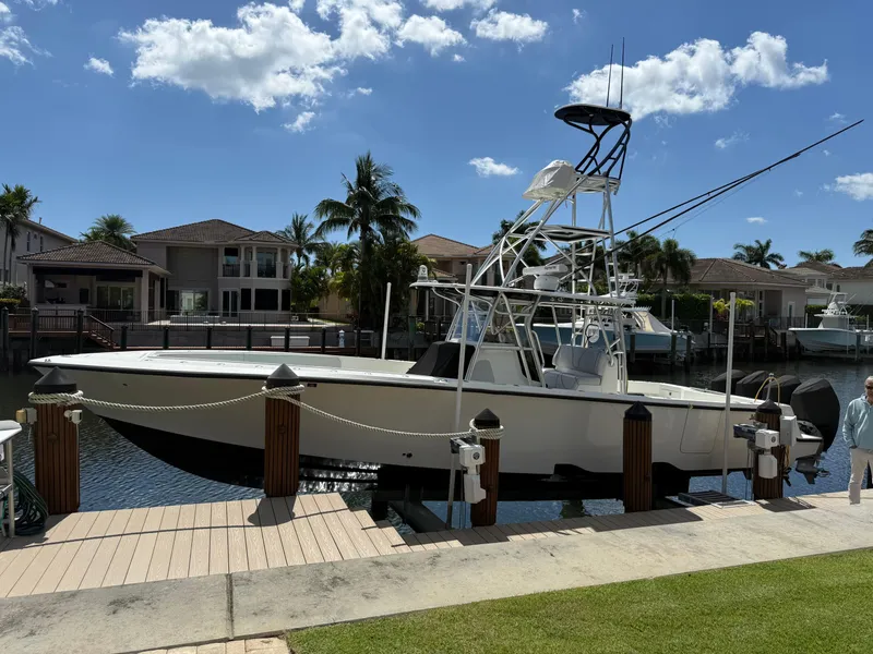 Slide: The Image of 2018 SeaVee 390Z boat docked by waterfront homes under a clear blue sky. - 10